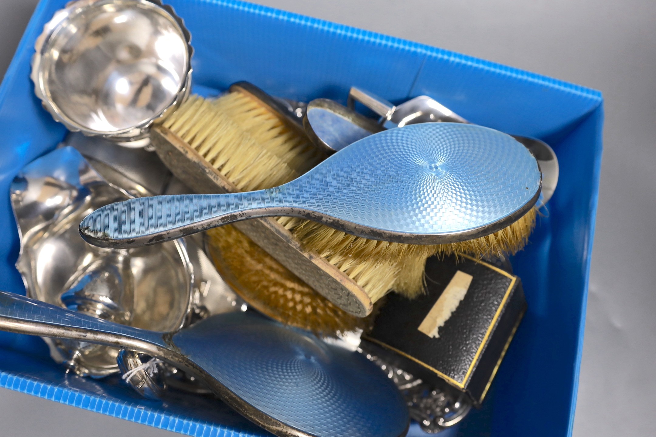 A collection of small silver including a repousse dressing tray, cream jug, sugar bowl, pepperette, sauceboat, two cigarette cases, compact, napkin ring and a mounted enamel mirror and brush set, weighable silver 41.5oz.